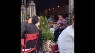 Man playing guitar and lady singing at restaurant