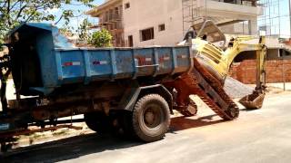 Retroescavadeira Desembarcando da caçamba de caminhão