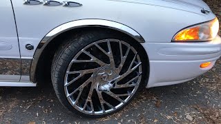 2004 Buick Lesabre sitting on 22”AZA-505 chrome wheels wrapped around 265/35-22 Lexani tires.