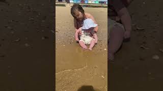 Baby boys first time with toes in the sand