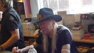 Johnny Winter signing autographs, Named one of 100 Greatest Guitarists - TopSignatures.com