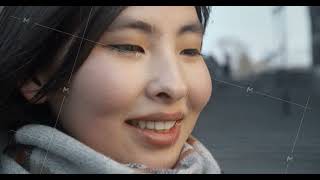 Portrait of an asian girl standing on the street in the city. The wind blows the hair. Natural