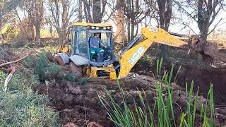 Retroescavadeira JCB movendo lodo