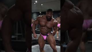 Big beefy muscle bull Jonny McKenna in pink posing trunks.