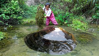 The beautiful woman walked through the culvert and unexpectedly discovered a large river clam