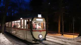 Weihnachtsmann kommt mit alter Straßenbahn als Fahrer durch den Wald untermalt mit Musik