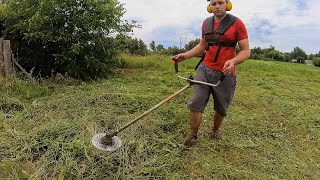 Mowing grass for drying to make hay for rabbits. Grass cutting with a trimmer