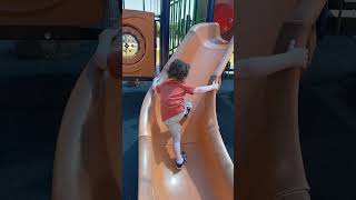 Lil guy climbing up the slide