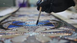 Close-up. Brush application of flux before soldering the stained-glass window. Artist's hands