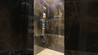 WASHROOM INTERIOR WITH GLOSSY BLACK TILES