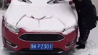 How the girl is making a human face at her car with snow