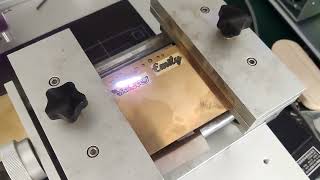 50W fiber laser marking machine cuts name on 1.1mm brass