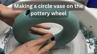 Making a green stoneware circle vase on the pottery wheel