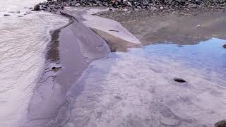 Cloudy and settled river water mixing Mt. Rainier