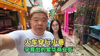 带越南妹打卡河内火车街，火车穿行而过，引来世界各地游客的围观