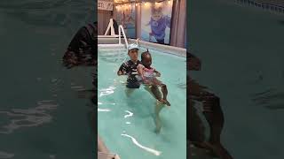 ISR instructor helping toddler manage her wiggles in back float.