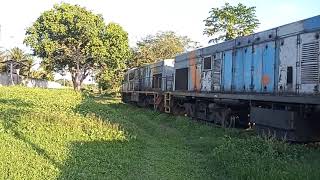 Trem com vagões de lastro e magnesita sendo puxados por uma U10B da VLI.