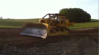 Cat D9G with a full U blade moving dirt.