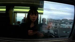 Reflections in the window of a train traveling through the Tokyo suburbs.