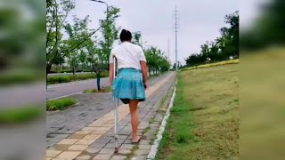 Amputee Lady Walking Near The Highway With One Crutch | Amputada | Hopping Woman