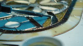 Close-up Soldering of stained glass seams. Artist's hands. Stained glass workshop, needlework. Self