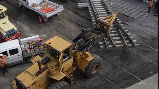 Moving brand new pieces of trackwork into place with an excavator