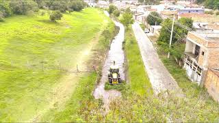 Retroescavadeira desobstruindo córrego(Backhoe unclogging stream)