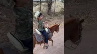 Sebastián en su poni arriando las vacas en el rancho