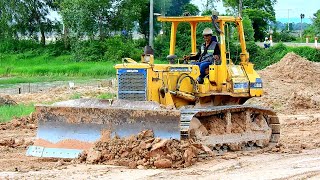 This is a big land reclamation activity, Processing by bulldozer KOMATSU D58E Dump truck unload soil