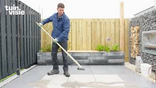 Tuinvisie: Keramische tegels buiten op een zandbed leggen