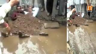 Gujarat: Citizens protest against bad roads by partially burying themselves in potholes