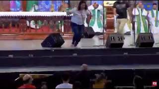 woman pushes a clergy off the stage