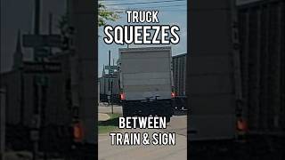 Truck Squeezes Between Train & Hits Street Sign