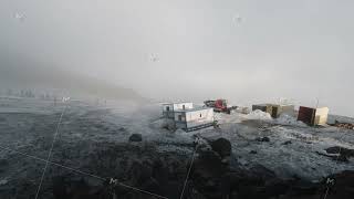 View from the hill top of a geological base with trailers and machinery. Clip. Foggy weather in