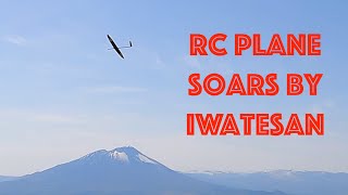 RC sailplane soars in front of Iwatesan and wind turbines