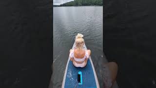 blonde mermaid gets paddleboard ride around the lake.