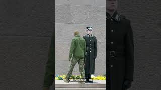 Latvian honor guard get his military uniform straightened