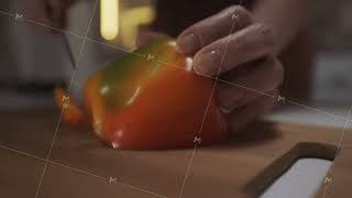 Close up of woman hands using kitchen knife to slice and cut the bell pepper on a wooden board