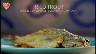 Fried trout on a bed of cereals, zucchini, and spinach