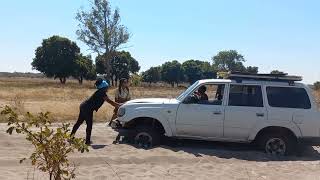 Strong Women Pushing a Toyota Land Cruiser in Sandy Liuwa Plains