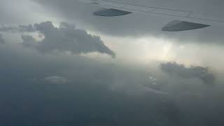 The plane is flying into a rain cloud. The plane is flying in the rain.