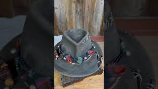 A unique hat made and restored from an old woolen hunting hat with accessories such as wooden dice.