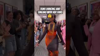 Tems dancing and singing with her fans