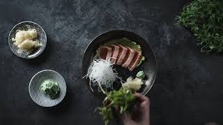 A CHEF PLATING A SERVING OF SALMON SAHIMI  SATISFYING!!!