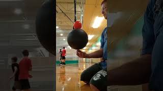 Spinning a small ball on top of a basketball.  Middle Age Belly Fun Circus