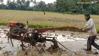 anak muda mengolah tanah dengan cepat  mengunakan traktor sawah Quick g 1000