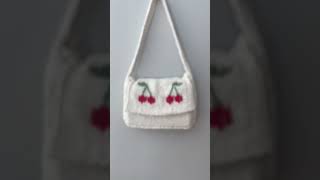 finishing touches on a little knitted bag #summerknits #knitting #knit #embroidery #cherry