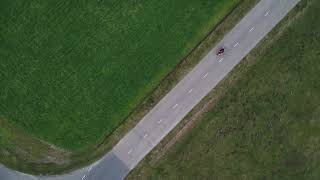 Aerial drone shot of motorcyclist driving down a bend road FREE STOCK VIDEO