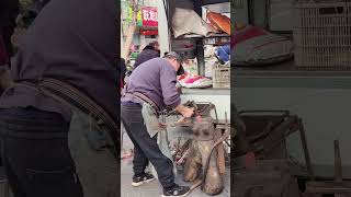 Blacksmiths forging farm tools at the market