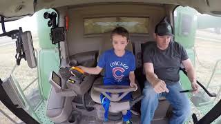 John Deere S 680 combine harvester under the control of a little boy